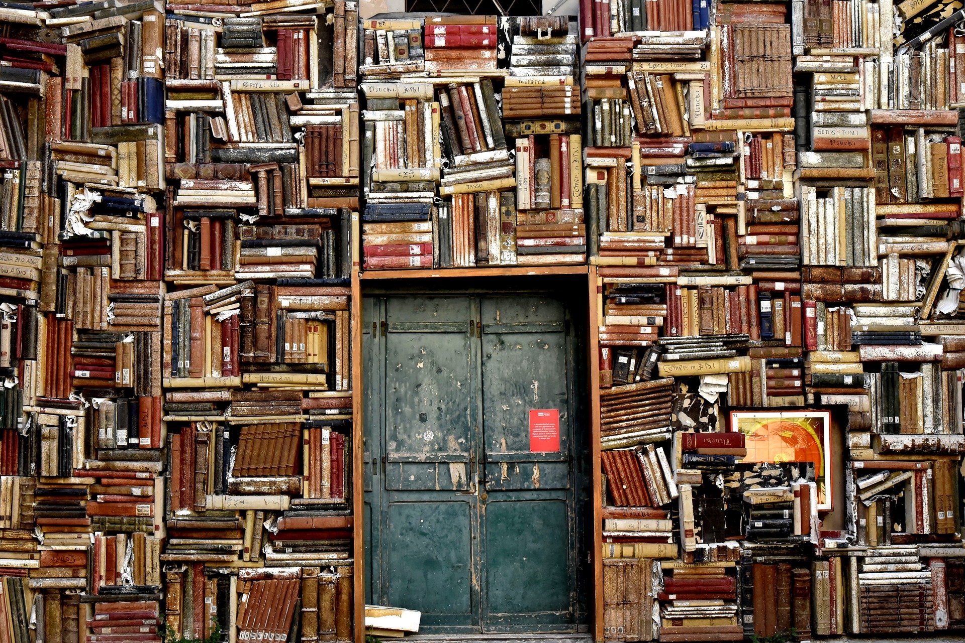 A tall stack of books around antique doors.