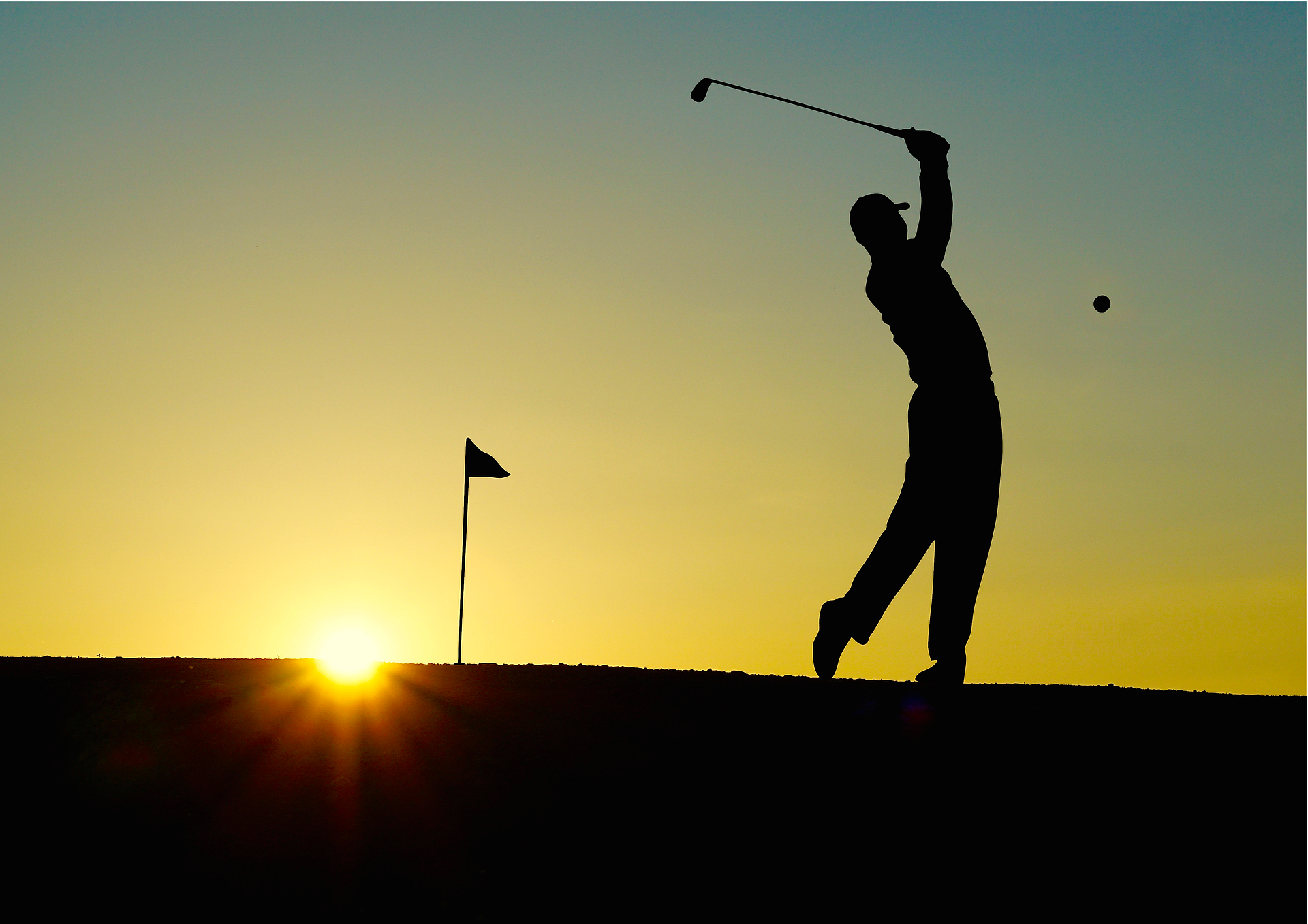A silhouette of a golfer taking a swing