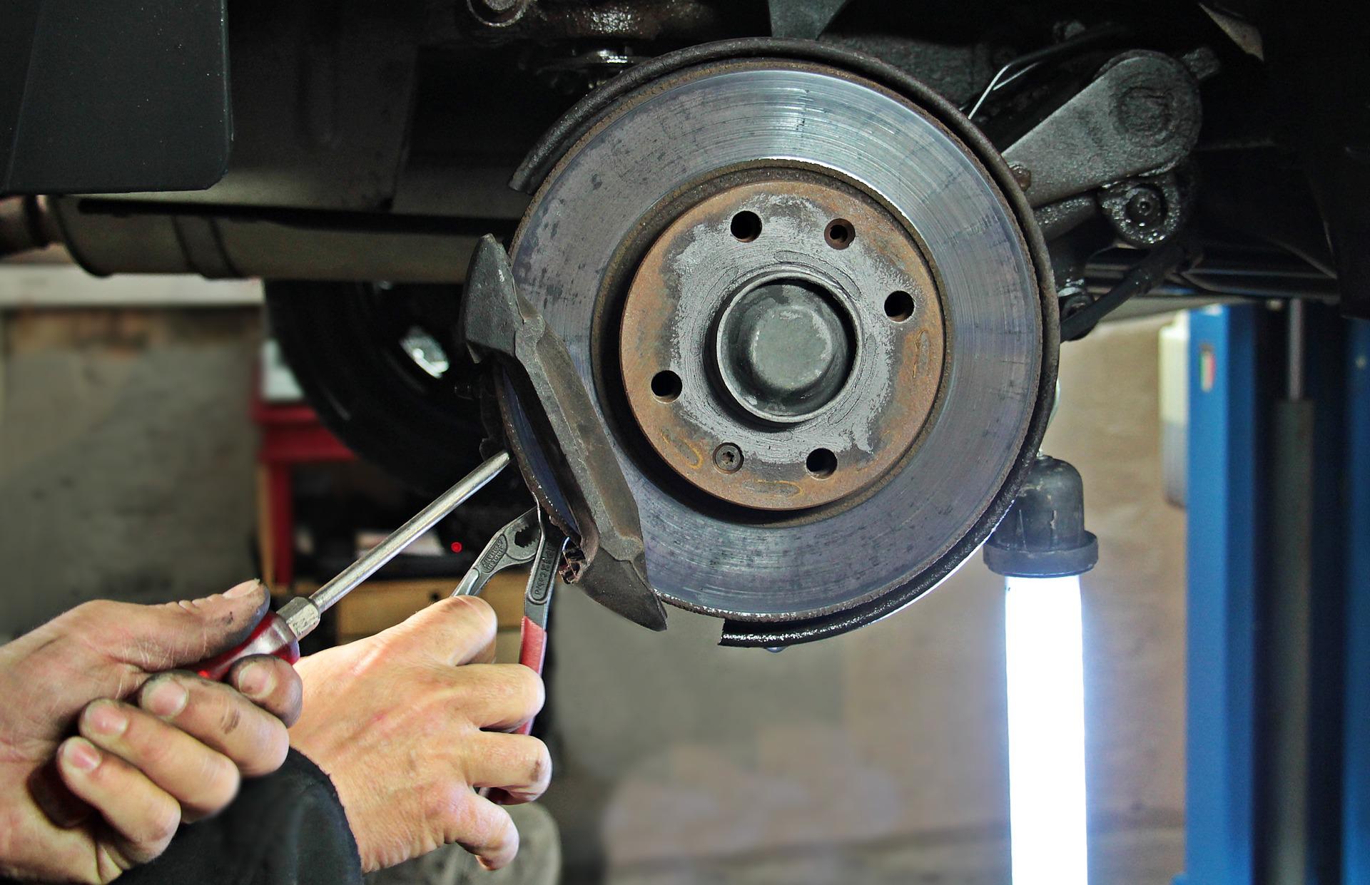A brakepad being serviced by an auto expert